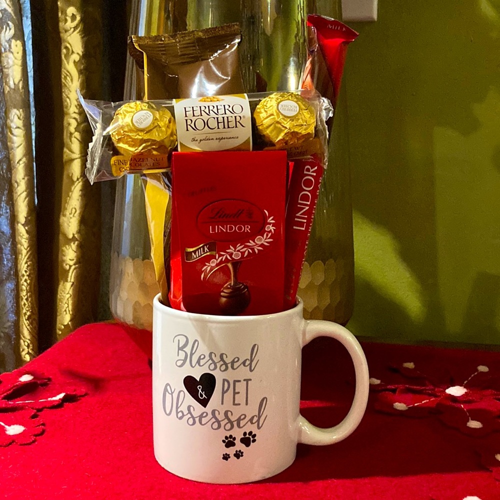 Ceramic mug filled with coffee, and Lindor and Ferrero Rocher chocolate goodies.